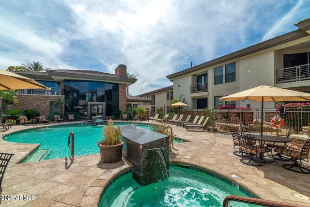 a patio with a table and chairs under an umbrella