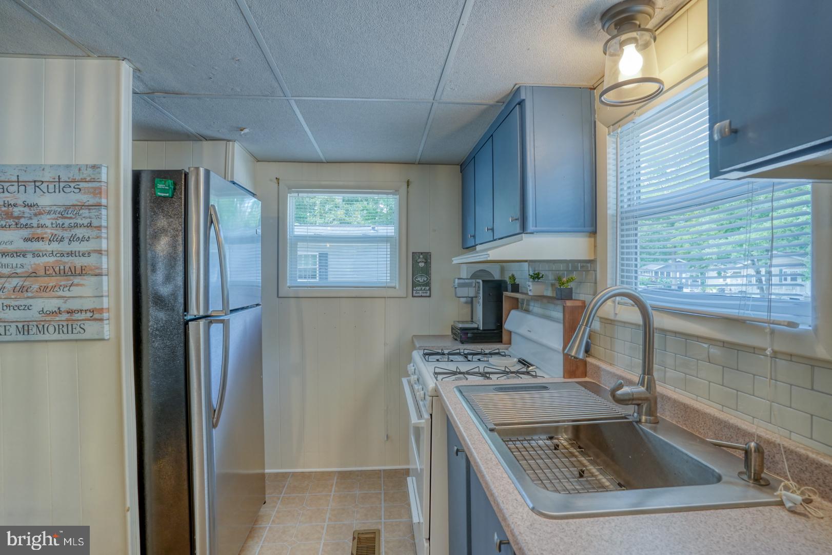 25780 Blue Ridge Street, Unit 4198 Millsboro, DE 19966 - Photo 21 of 36 a kitchen with kitchen island a sink stove and refrigerator