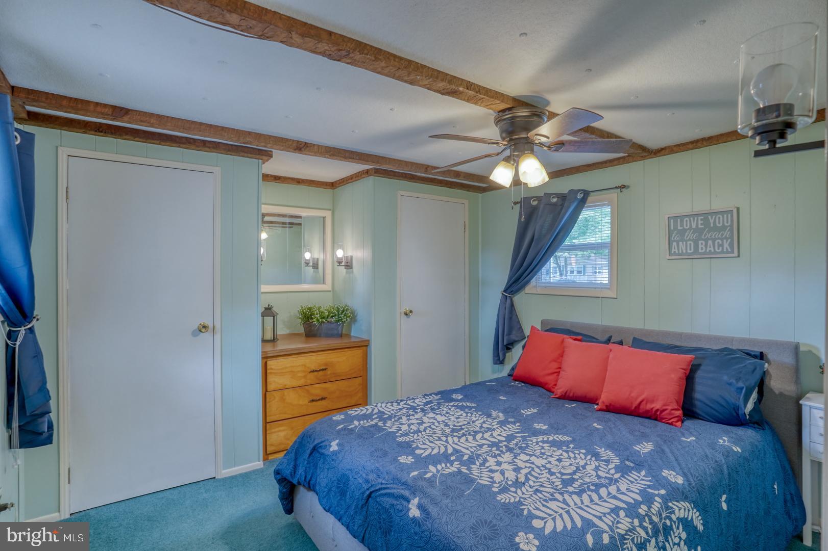 25780 Blue Ridge Street, Unit 4198 Millsboro, DE 19966 - Photo 25 of 36 a bedroom with a large bed and a chandelier