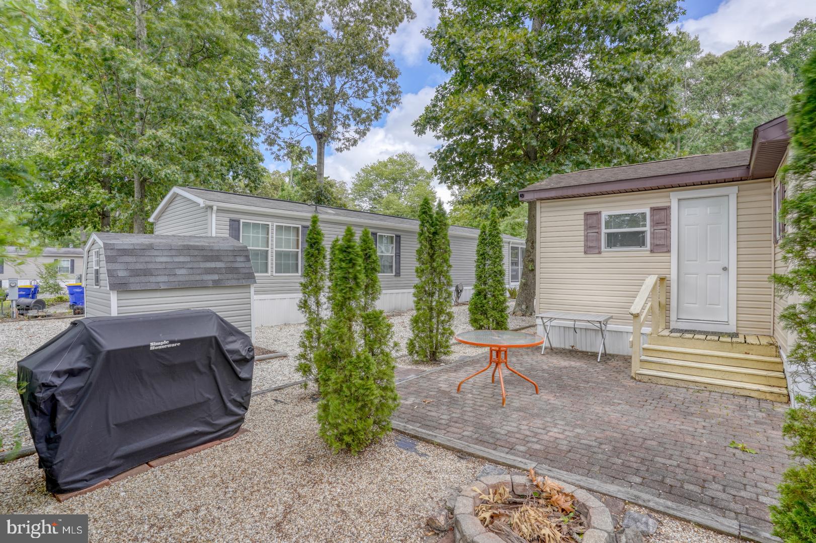 25780 Blue Ridge Street, Unit 4198 Millsboro, DE 19966 - Photo 10 of 36 a view of a patio with table and chairs potted plants and large tree