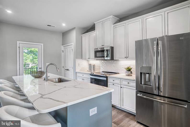 19756 Canopy Loop, Unit 328D Montgomery Village, MD 20886 - Photo 2 of 27 a kitchen with stainless steel appliances white cabinets a sink and a refrigerator