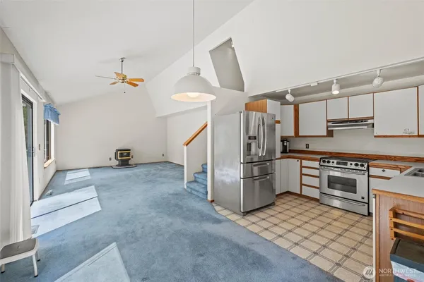 a kitchen with a stove sink and cabinets