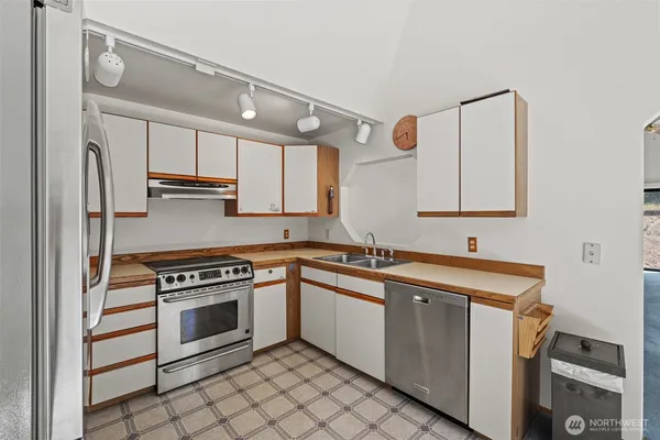 a kitchen with stainless steel appliances granite countertop a refrigerator sink and stove