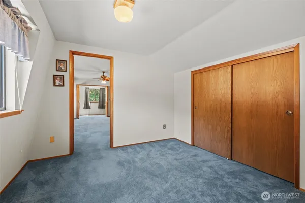 an empty room with a window and a ceiling fan