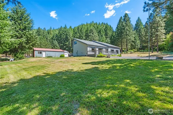 a house view with swimming pool and trees in the background