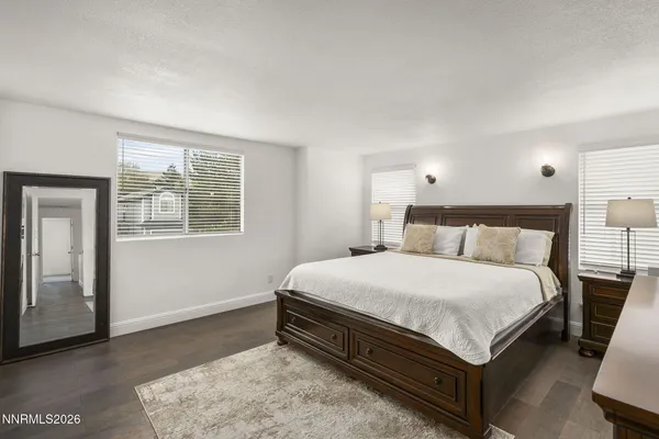 a large bed sitting in a bedroom next to a window