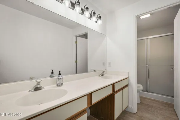 a bathroom with double vanity sink and a mirror