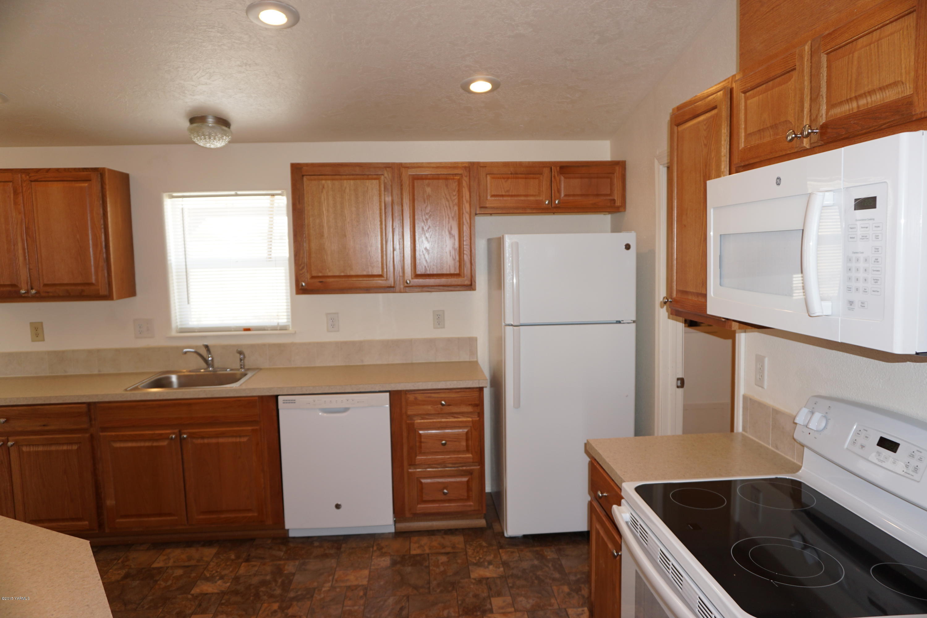 11785 Postma Road Moxee, WA 98936 - Photo 6 of 22 a kitchen with a sink a stove and refrigerator