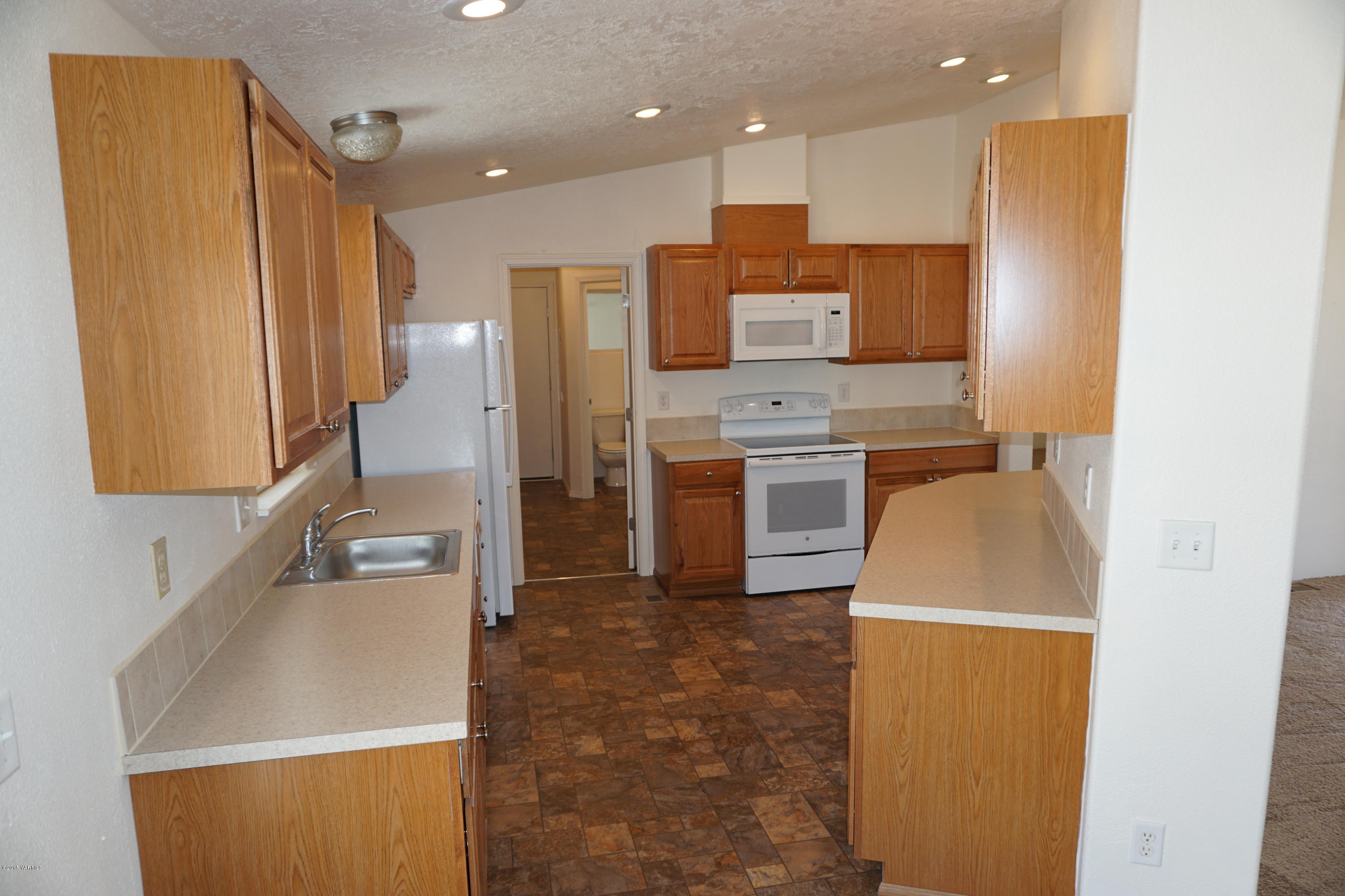 11785 Postma Road Moxee, WA 98936 - Photo 7 of 22 a kitchen with stainless steel appliances granite countertop a sink a stove and a refrigerator