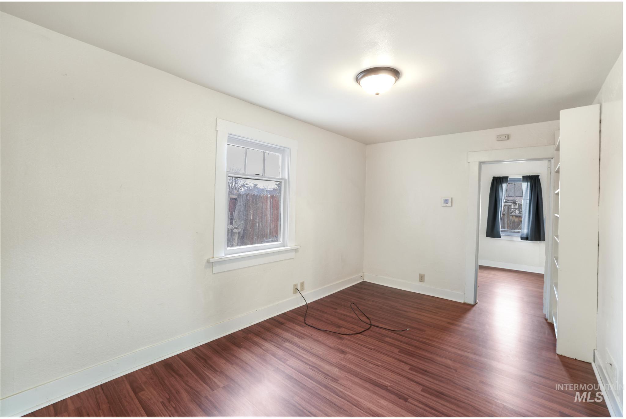 250 Elm Street Twin Falls, ID 83301 - Photo 11 of 28 Empty room featuring dark wood-style floors and healthy amount of natural light