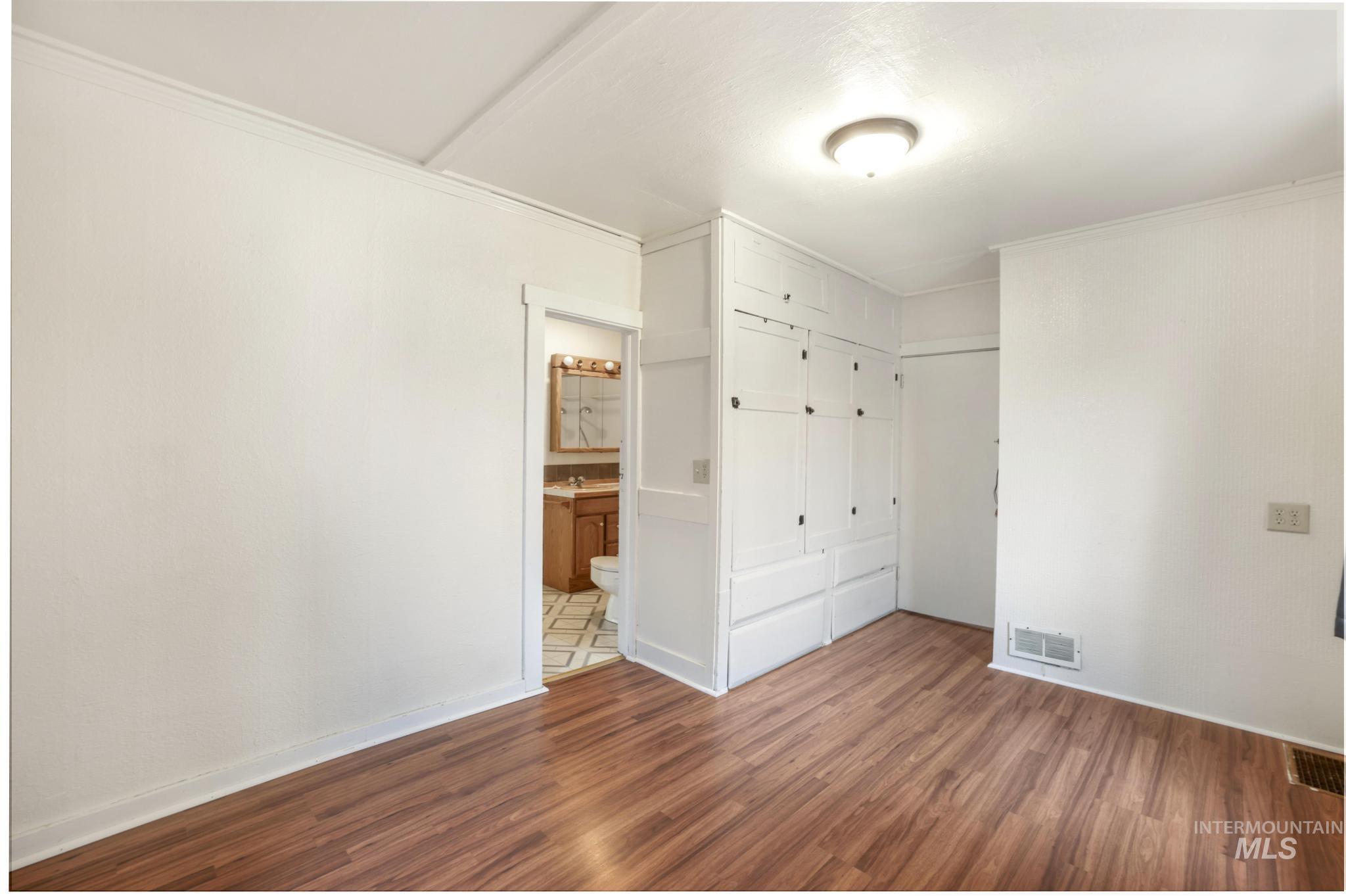 250 Elm Street Twin Falls, ID 83301 - Photo 20 of 28 Unfurnished bedroom with a closet, wood finished floors, crown molding, and ensuite bath