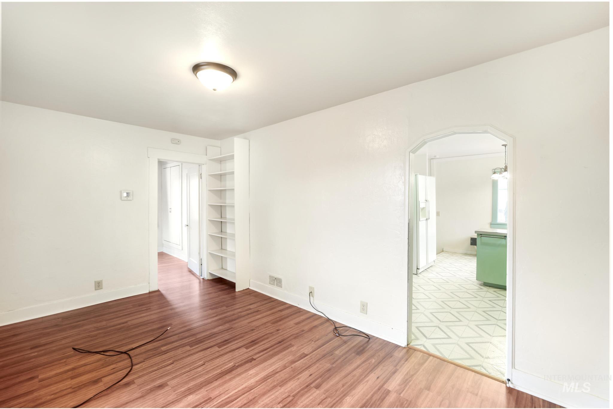 250 Elm Street Twin Falls, ID 83301 - Photo 10 of 28 Unfurnished room featuring arched walkways, light wood-type flooring, and built in shelves