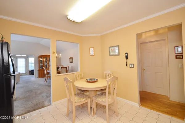 a kitchen with stainless steel appliances granite countertop a stove top oven a sink a refrigerator and white cabinets