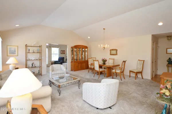 a living room with furniture a dining table and a chandelier