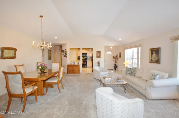 a kitchen with stainless steel appliances kitchen island granite countertop a sink a stove a microwave a dining table and chairs