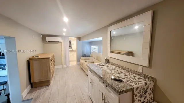 a spacious bathroom with a granite countertop sink and a mirror