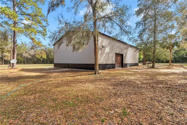 a view of a house with a yard and large tree