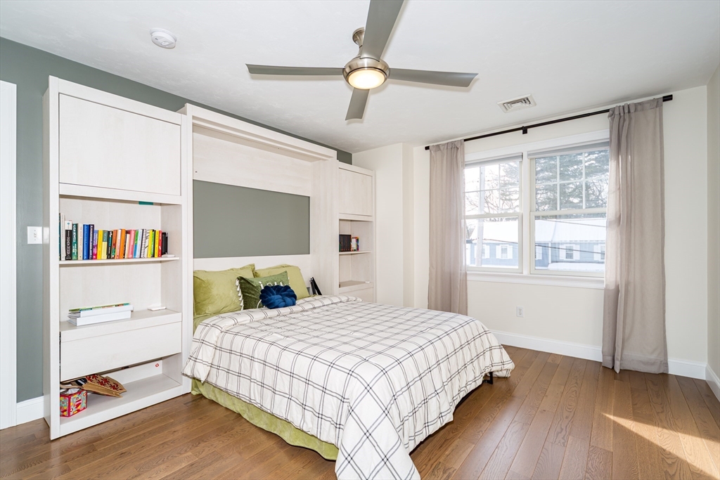 26 Wellesley Avenue, Unit B Natick, MA 01760 - Photo 20 of 34 a bedroom with a large bed and a chandelier