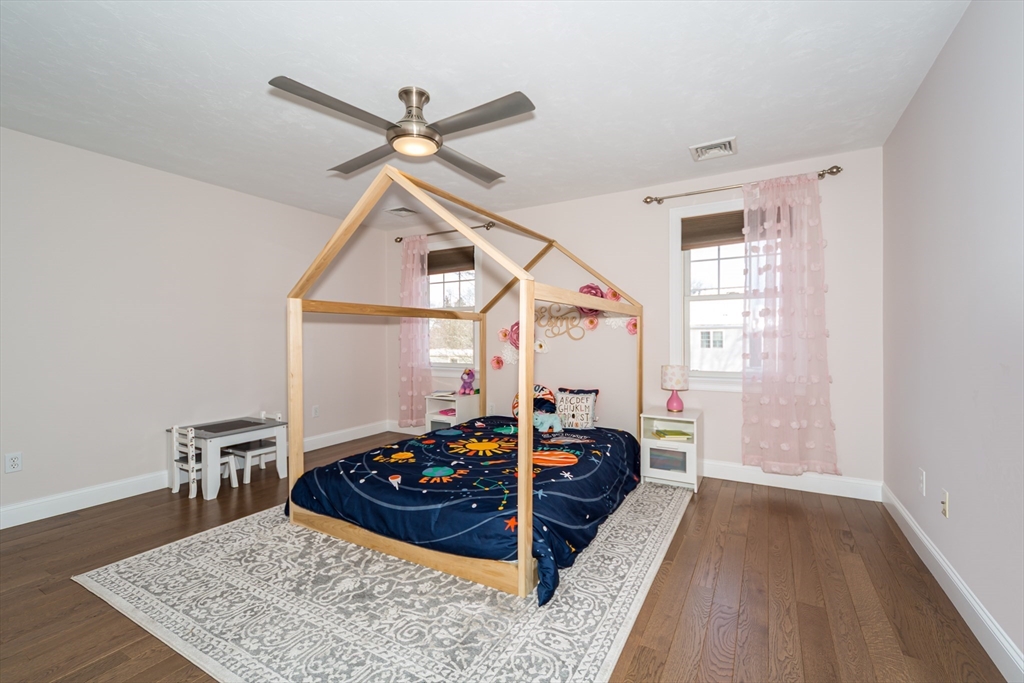 26 Wellesley Avenue, Unit B Natick, MA 01760 - Photo 22 of 34 a room with a bed and a wooden floor