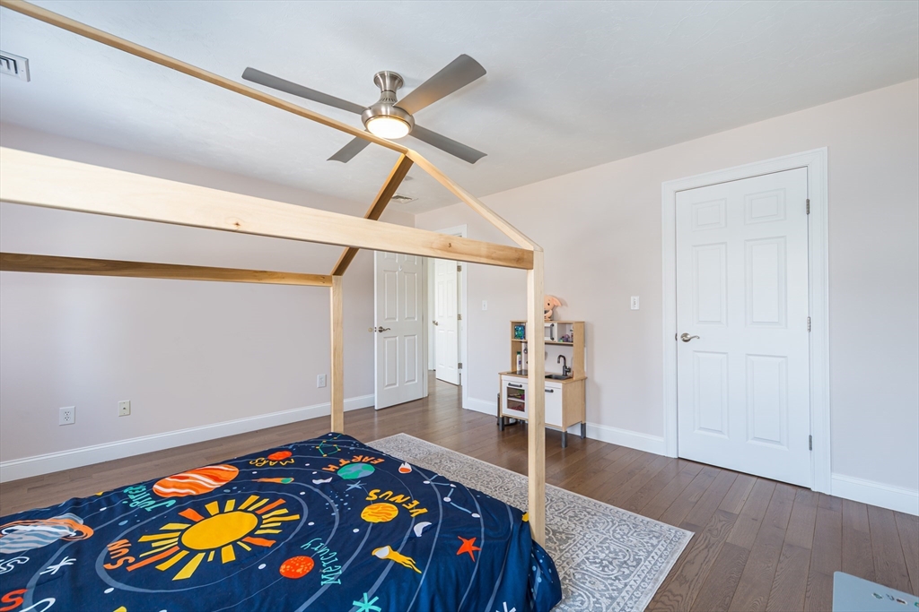 26 Wellesley Avenue, Unit B Natick, MA 01760 - Photo 23 of 34 a bedroom with a bed and a book shelf