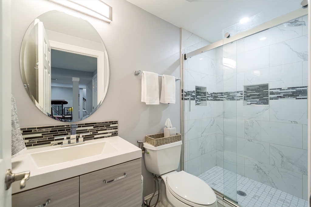 26 Wellesley Avenue, Unit B Natick, MA 01760 - Photo 30 of 34 a bathroom with a sink a toilet a mirror and shower