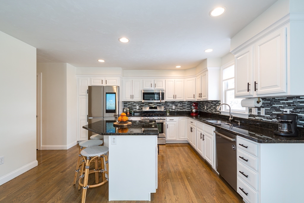 26 Wellesley Avenue, Unit B Natick, MA 01760 - Photo 10 of 34 a kitchen with stainless steel appliances granite countertop a stove top oven a sink a refrigerator white cabinets and wooden floor