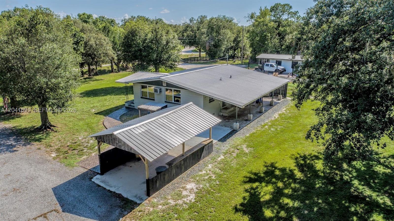 1270 Nobles Road LaBelle, FL 33935 - Photo 2 of 18 a view of a patio with table and chairs with wooden floor and fence