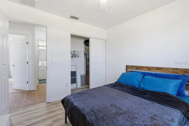 a bedroom with a bed and wooden floor