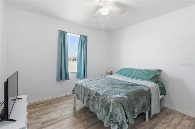 a bedroom with a bed and a flat tv screen on a dresser