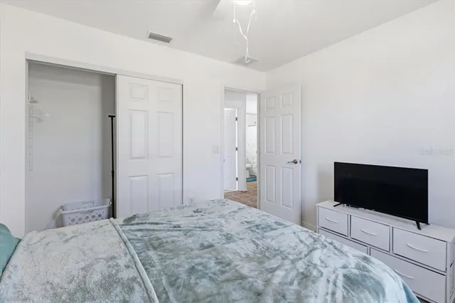 a bedroom with a bed and a flat screen tv