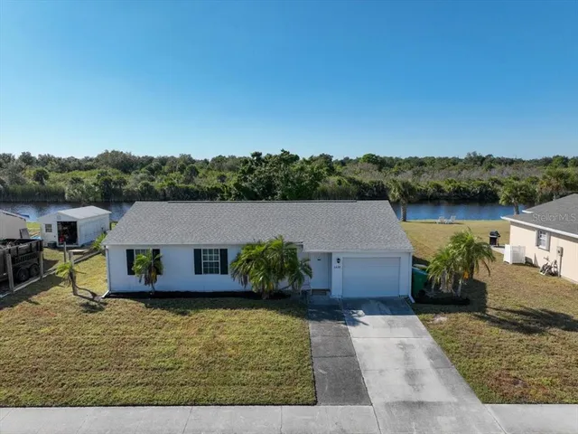 an aerial view of a house with swimming pool and a yard