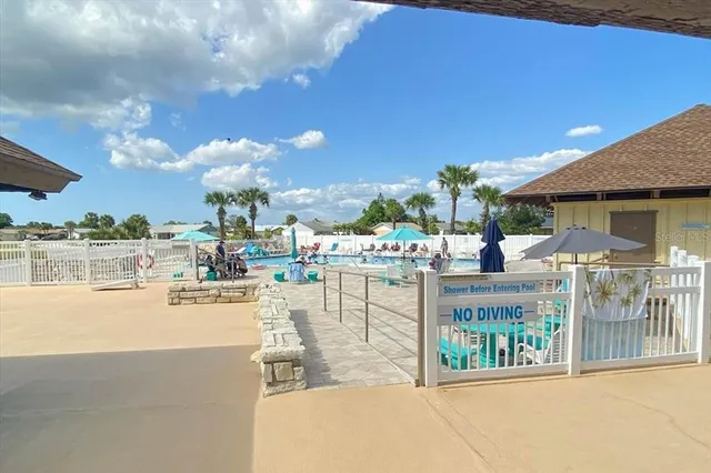 a view of a swimming pool with a patio and a yard