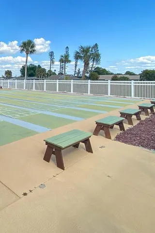 a view of a swimming pool with a yard and wooden fence
