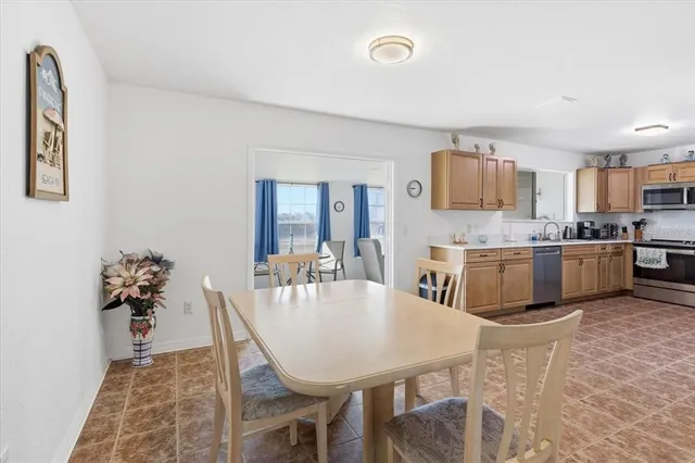 a open kitchen with stainless steel appliances a dining table and chairs
