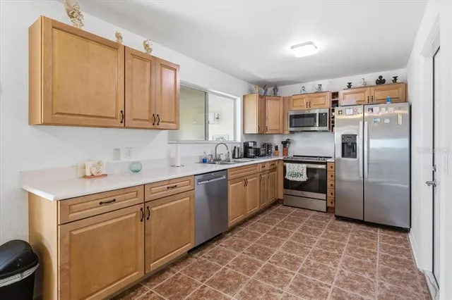 a kitchen with stainless steel appliances granite countertop a sink a stove a refrigerator a microwave oven with cabinets