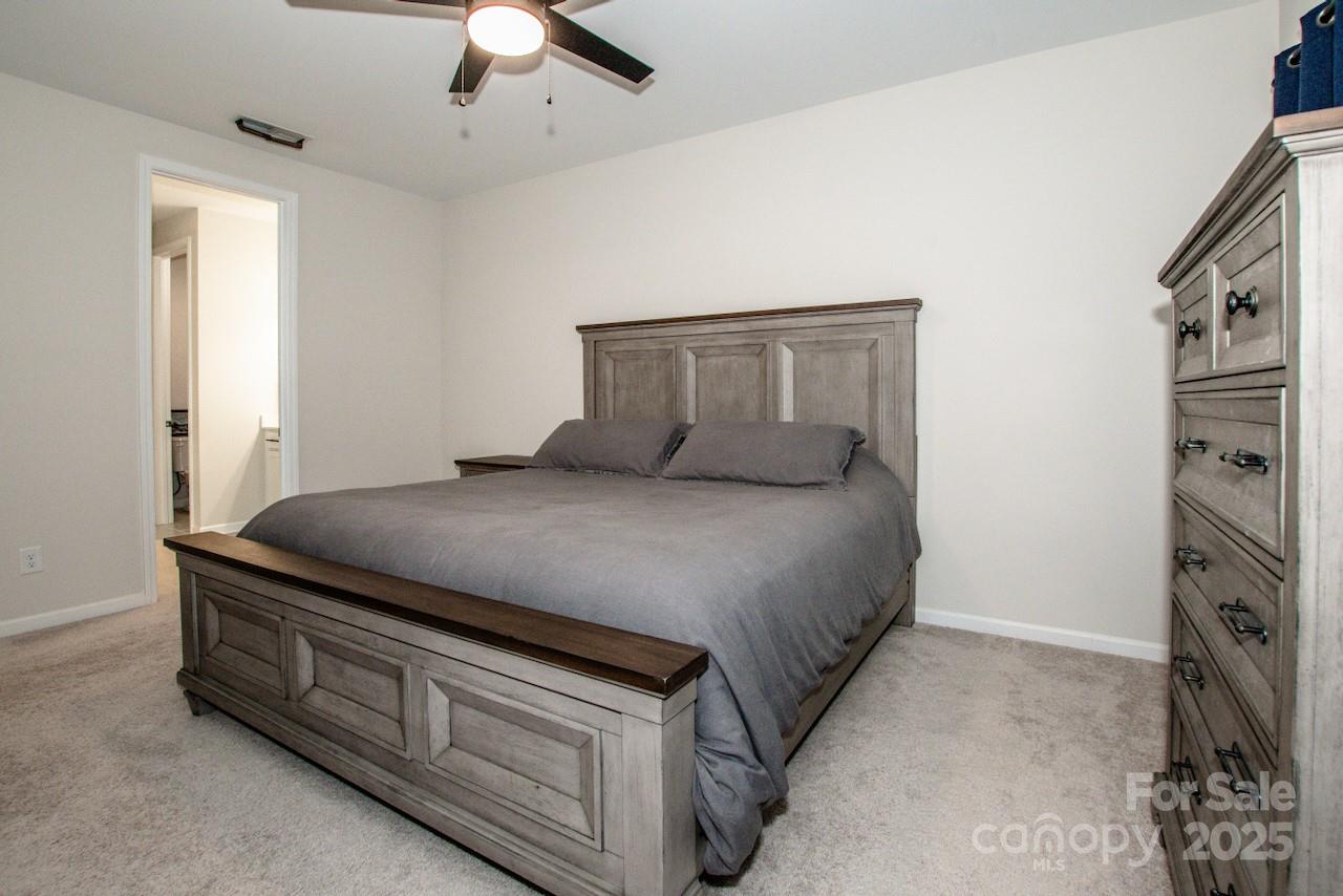 1270 Brawley School Road, Unit F Mooresville, NC 28117 - Photo 28 of 47 a bedroom with a bed and a chandelier