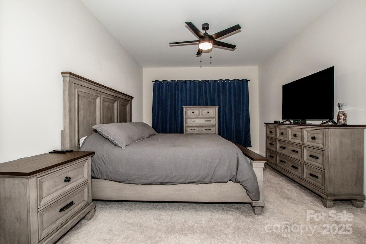 1270 Brawley School Road, Unit F Mooresville, NC 28117 - Photo 29 of 47 a bedroom with a bed and a flat screen tv