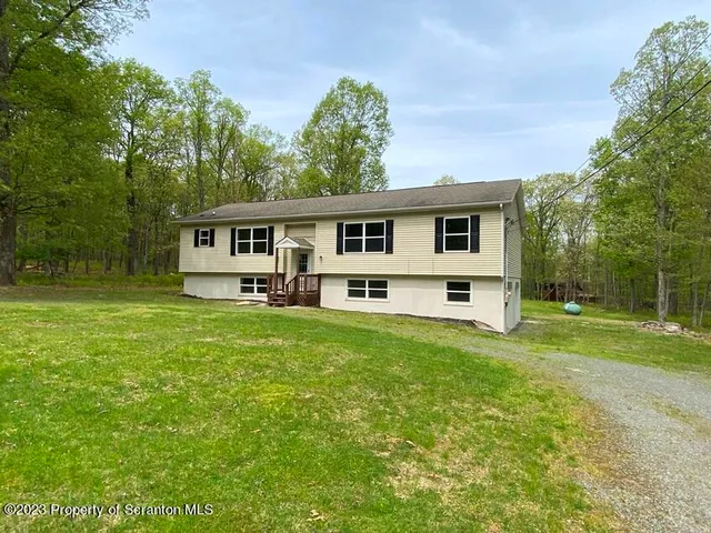 a front view of house with yard and green space