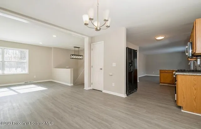 a view of a room with wooden floor and a ceiling fan