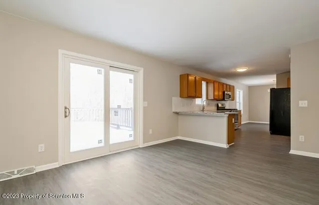 a view of a kitchen with wooden floor and electronic appliances