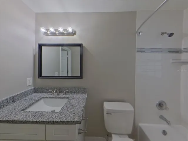 a bathroom with a bathtub toilet and window