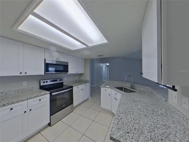 a kitchen with stainless steel appliances granite countertop a sink stove and cabinets
