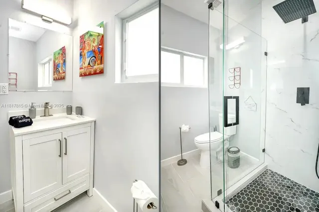 a bathroom with a sink a toilet and shower