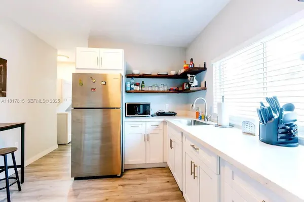 a kitchen with a refrigerator a stove and wooden cabinets