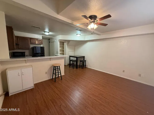 a view of a livingroom with furniture wooden floor a ceiling fan and a window