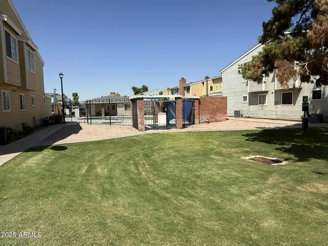 a large white building with a big yard and large trees