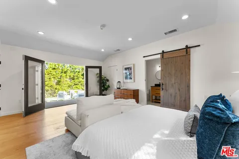 a bedroom with a bed and a large window