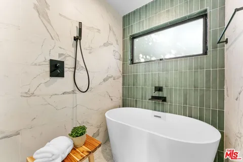 a bathroom with a white bath tub and a shower