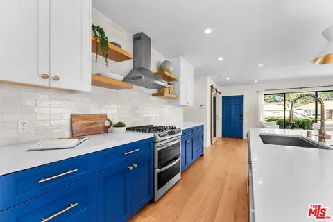 a kitchen with stainless steel appliances granite countertop a sink and wooden cabinets