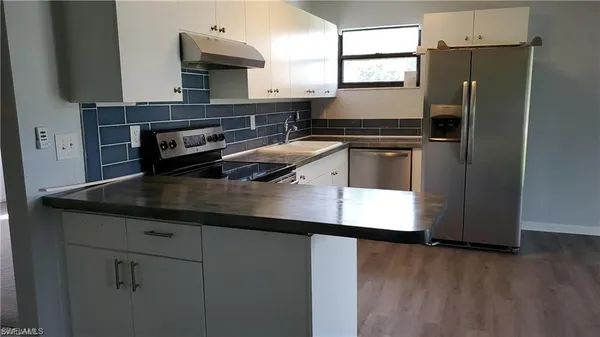 a kitchen with kitchen island a counter appliances a sink and cabinets